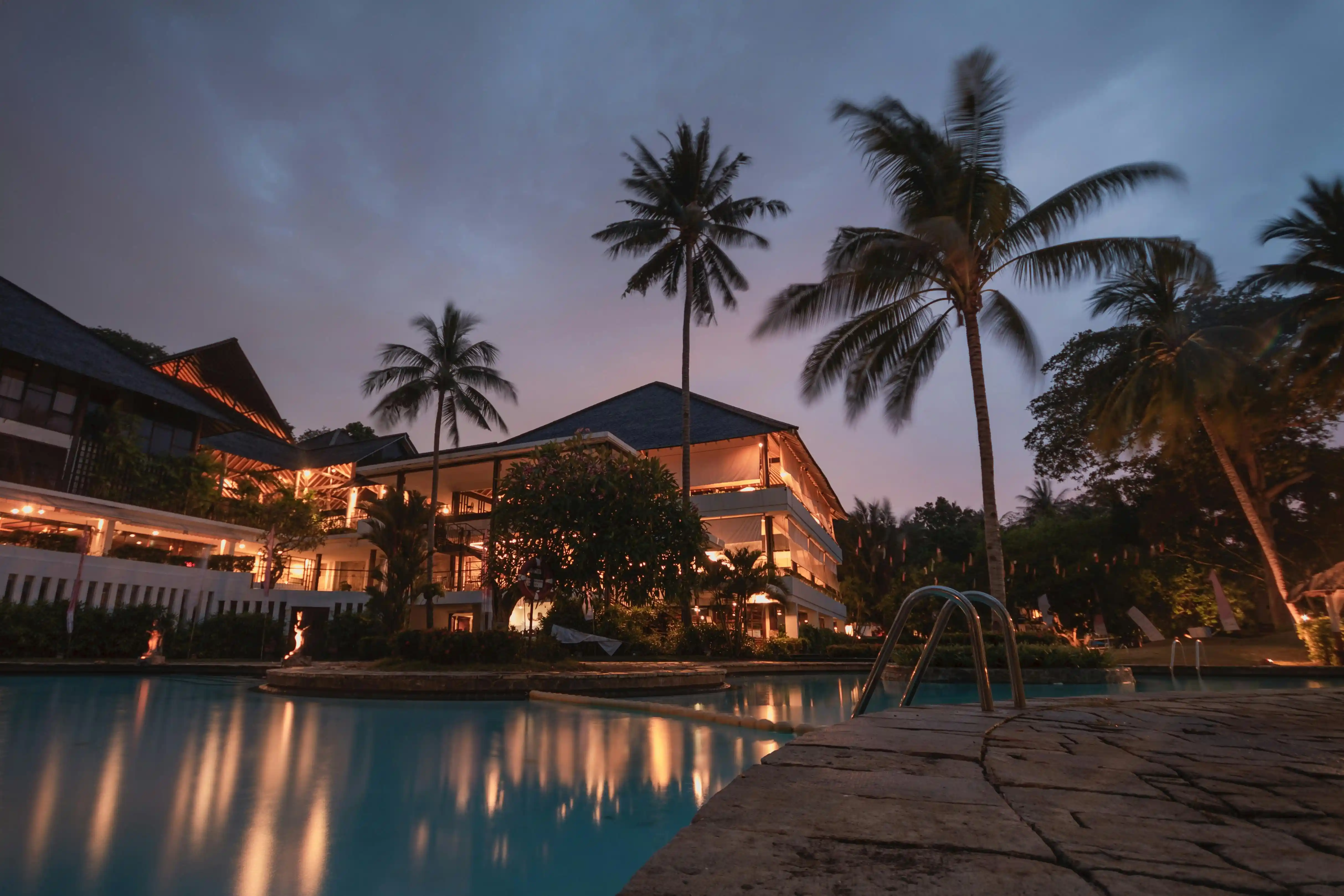 A panoramic view of the Vista Valley hotel nestled in a lush, green valley at sunset.